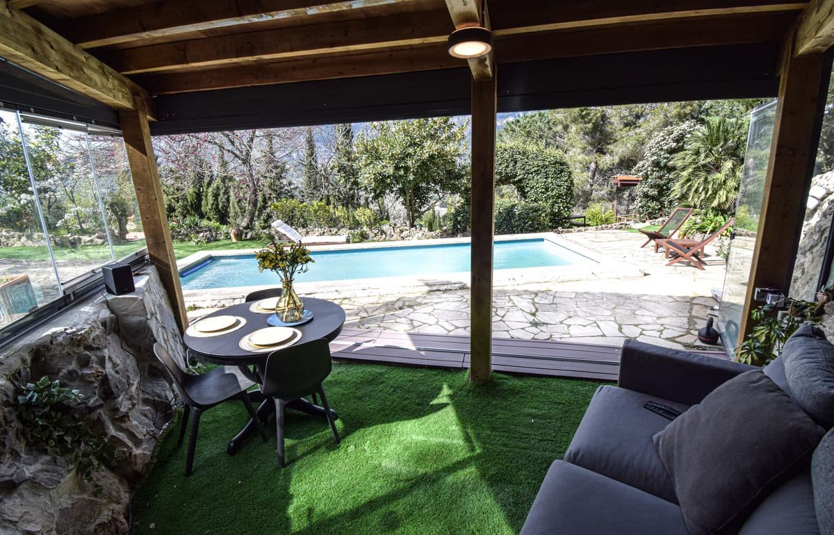 Inside Dragonfly, the table set, looking out over the pool to the spring garden.