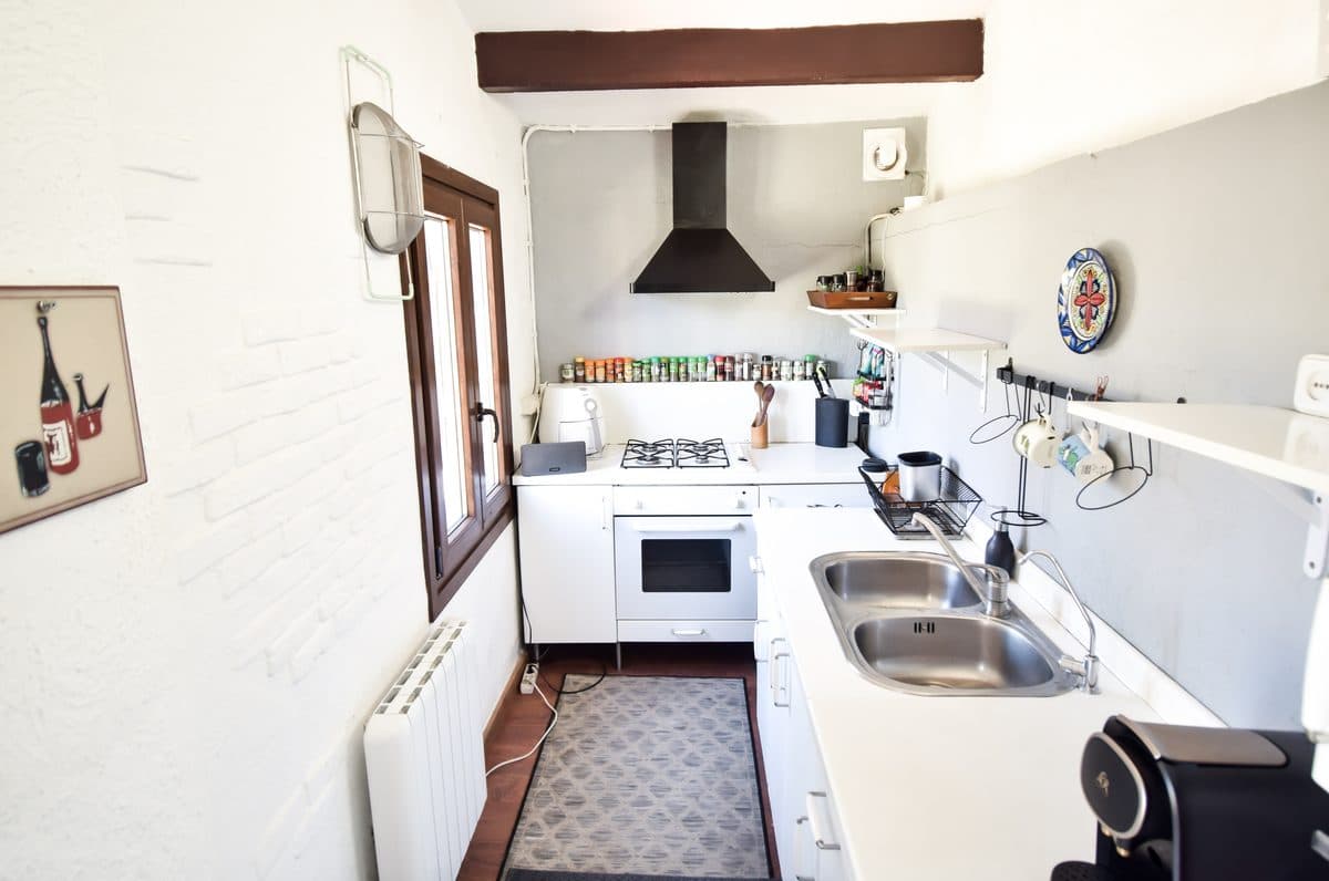 The main house galley kitchen: gas hob, oven, spice rail, window light.