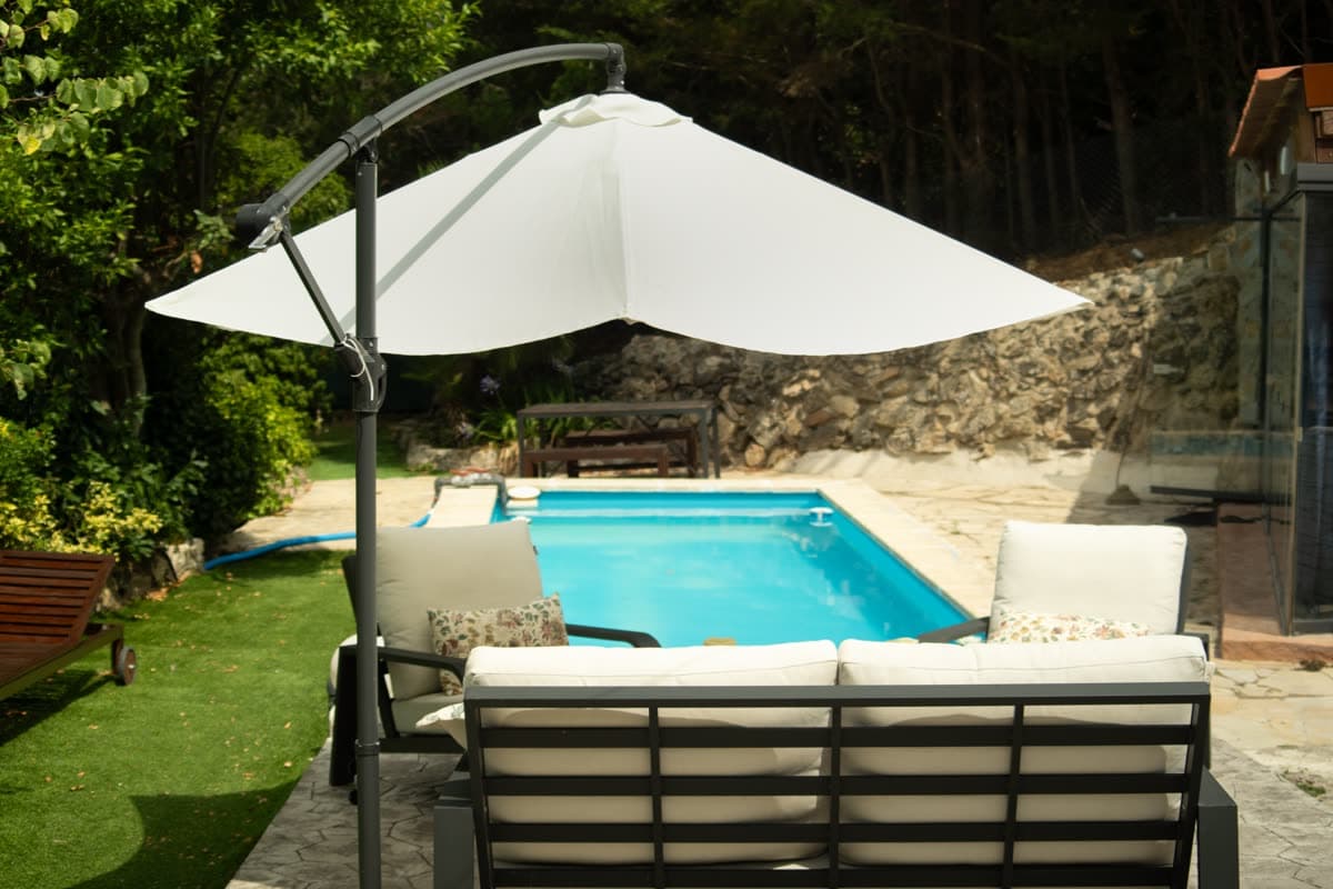 The pool on its stone terrace, with loungers and a parasol.